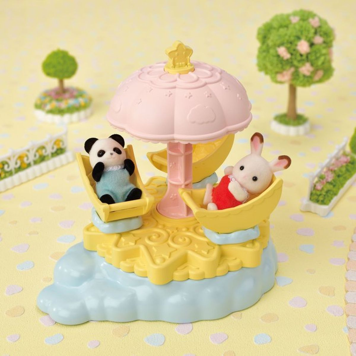 Ein Spielzeugkarussell zeigt einen Panda und einen Hasen in gelben Sitzen unter einem rosa Schirmdach auf einer blauen Wolke.