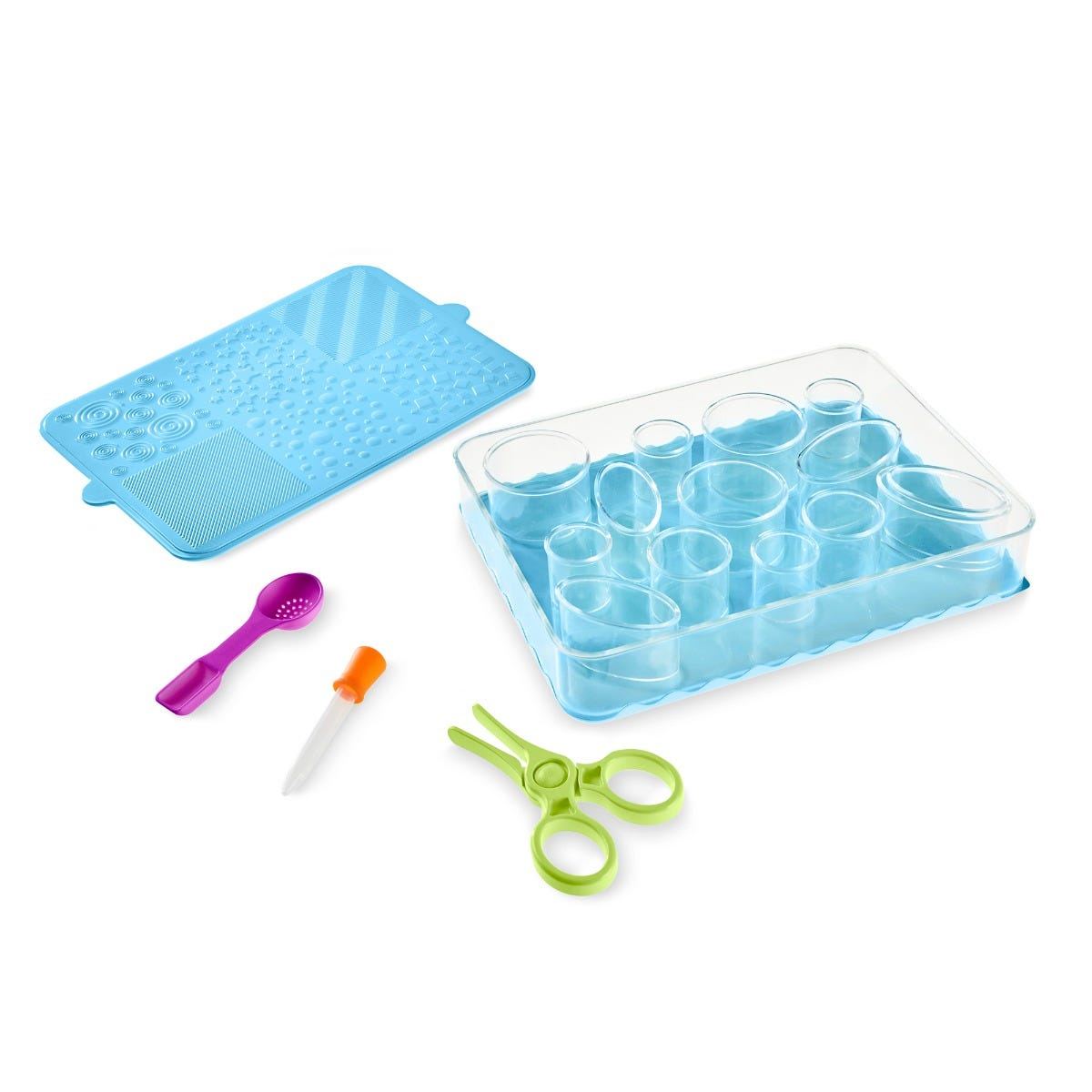 Eine blaue strukturierte Matte, ein Behälter mit klaren Zylindern, ein lila Löffel, eine Pipette und grüne Spielzeugschere.