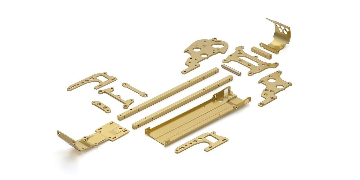 Verschiedene goldfarbene Metallteile für den Modellbau sind auf einer weißen Oberfläche ausgebreitet.