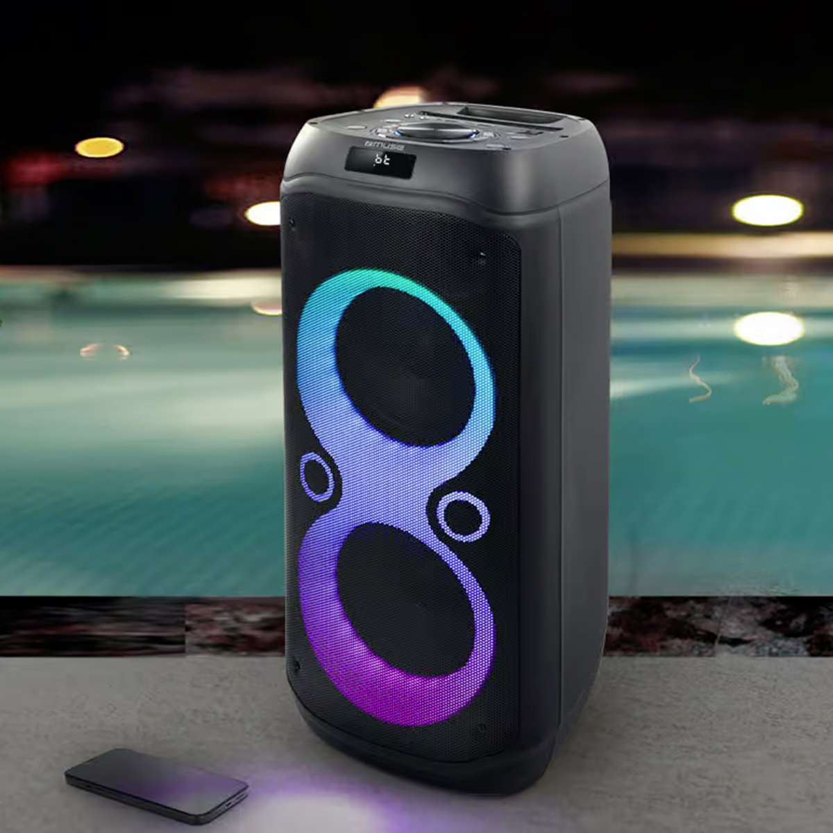 Ein schwarzer Standlautsprecher mit blauer und lila LED-Beleuchtung steht am Pool, davor liegt ein Smartphone.
