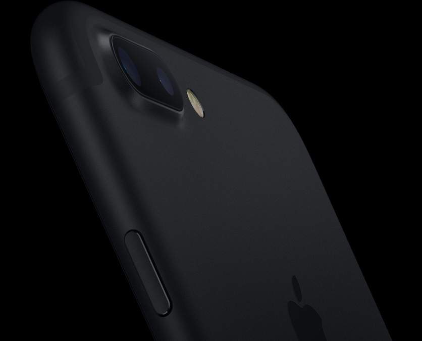 Zbliżenie czarnego tyłu iPhone'a z podwójnym aparatem i logo Apple na ciemnym tle.