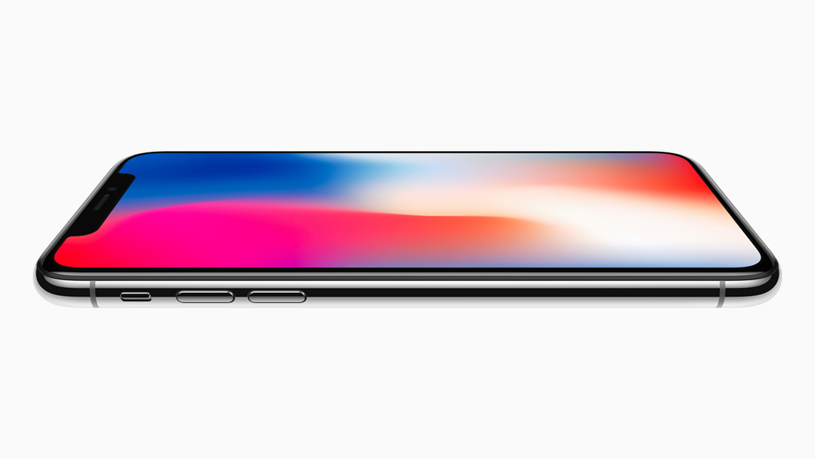Smartfon ze srebrną krawędzią i kolorowym ekranem leży poziomo na białym tle.
