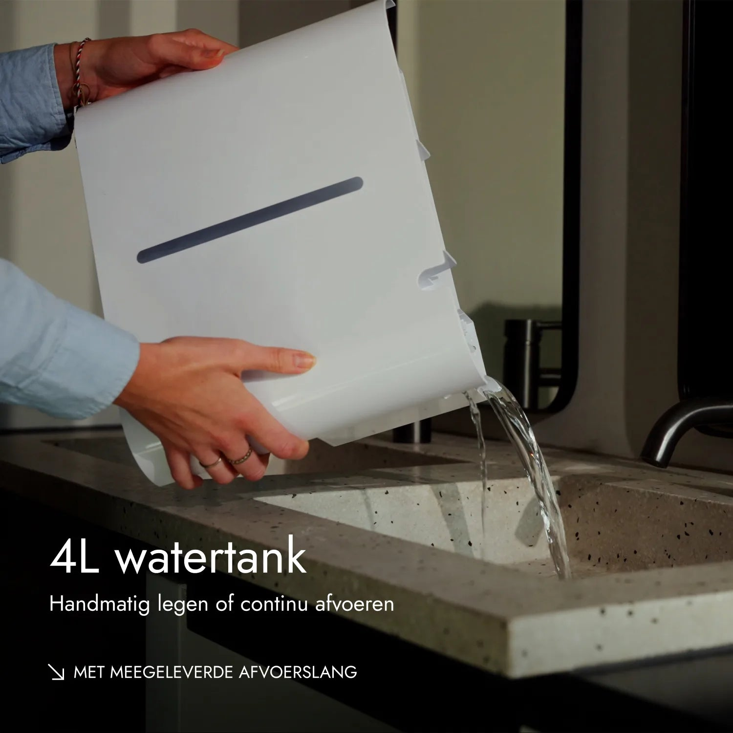 Eine Person leert einen weißen Wassertank in ein Waschbecken.