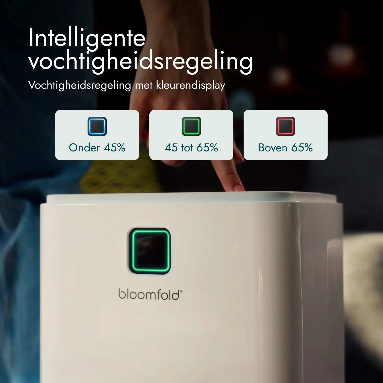 Person zeigt auf einen weißen bloomfold Luftentfeuchter mit Farbdisplay für Feuchtigkeit.