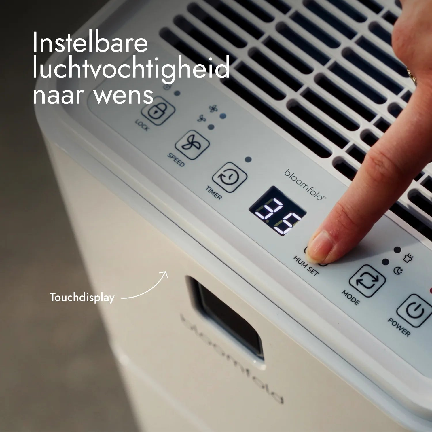 Hand berührt das Touch-Display eines weißen Bloomfold-Luftentfeuchters zur Einstellung der Luftfeuchtigkeit.