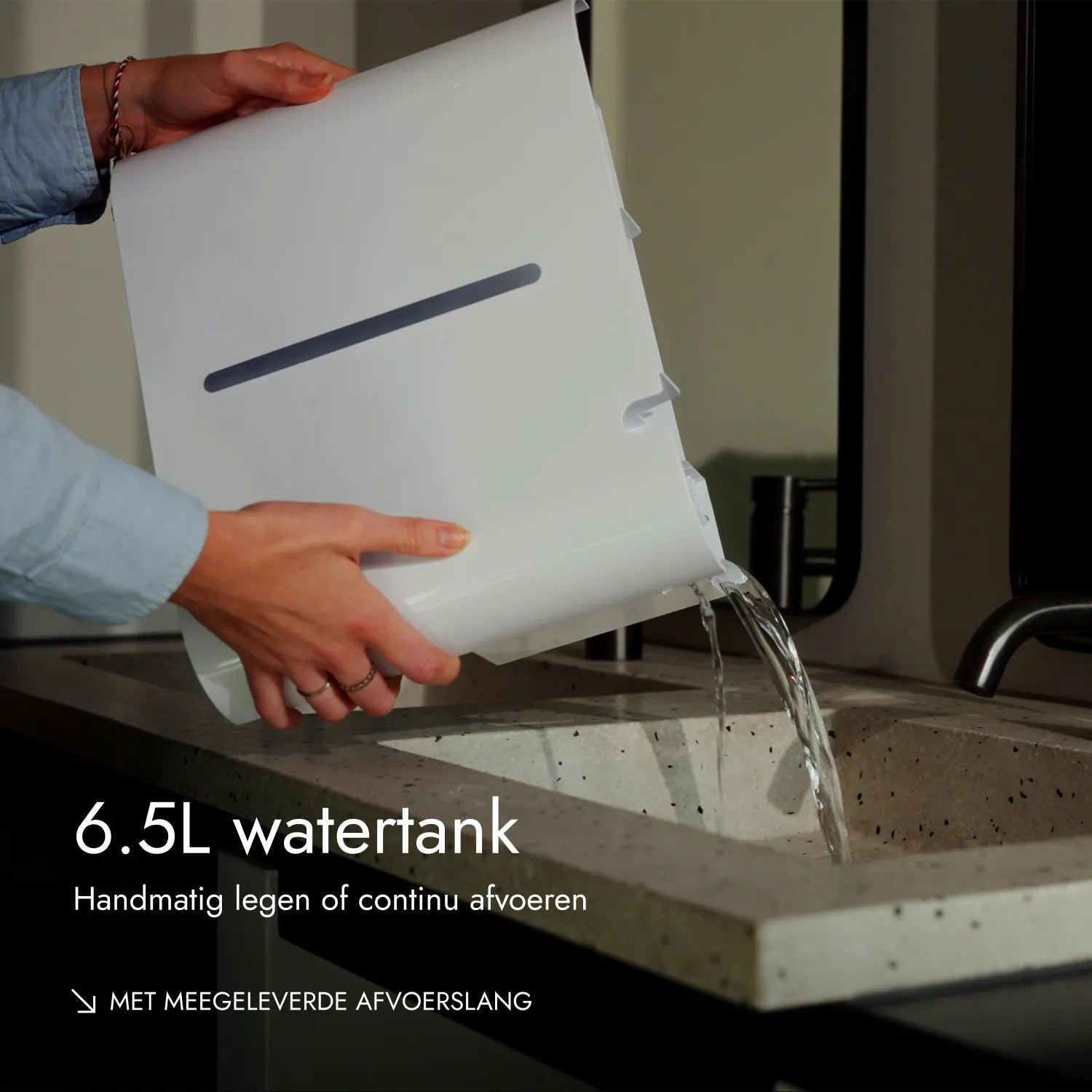 Person gießt Wasser aus einem weißen 6.5L Wassertank in ein Waschbecken.