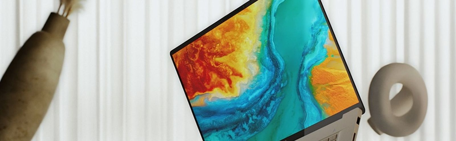 Ein Laptop mit einem lebendigen abstrakten Hintergrundbild in Blau, Orange und Gelb vor einem weißen Hintergrund.