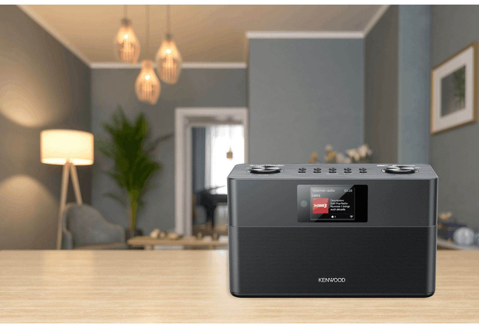 Una radio internet Kenwood nera su una superficie di legno in un soggiorno moderno.