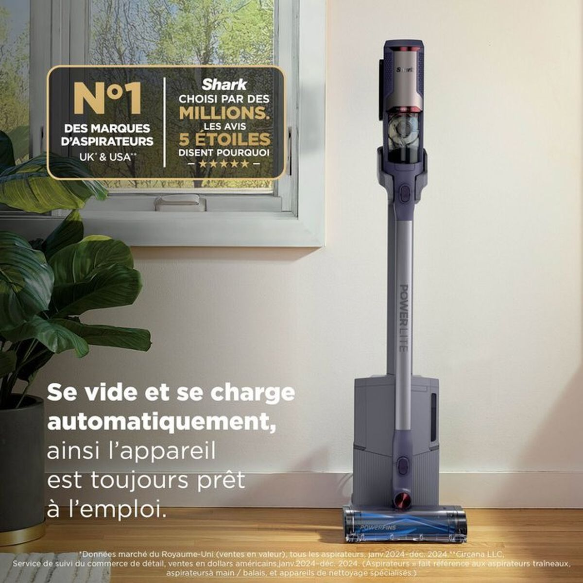 Un aspirapolvere senza fili grigio sulla sua base di ricarica contro una parete.