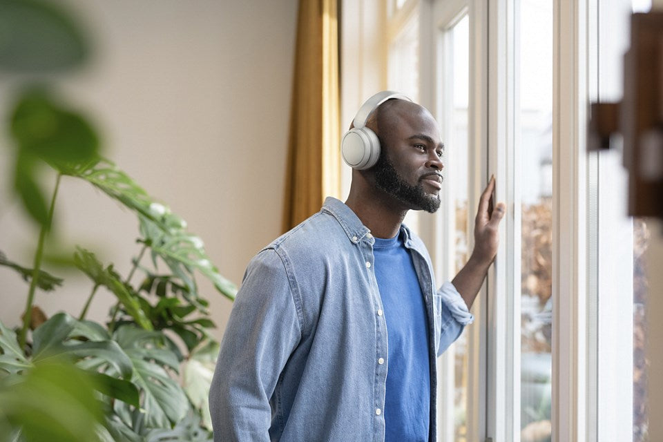 Un homme heureux portant un casque regarde par la fenêtre.