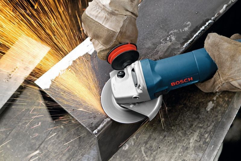 Ein Arbeiter in Handschuhen schneidet mit einem blauen Bosch-Winkelschleifer Metall, wobei helle Funken sprühen.