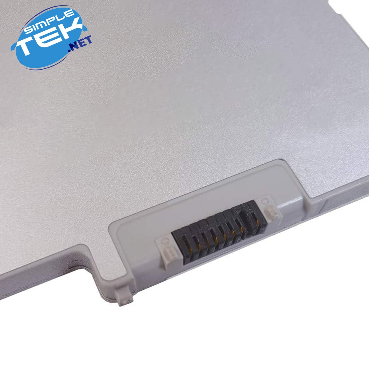 Primo piano di una batteria per laptop con finitura argentata e contatti elettrici visibili.