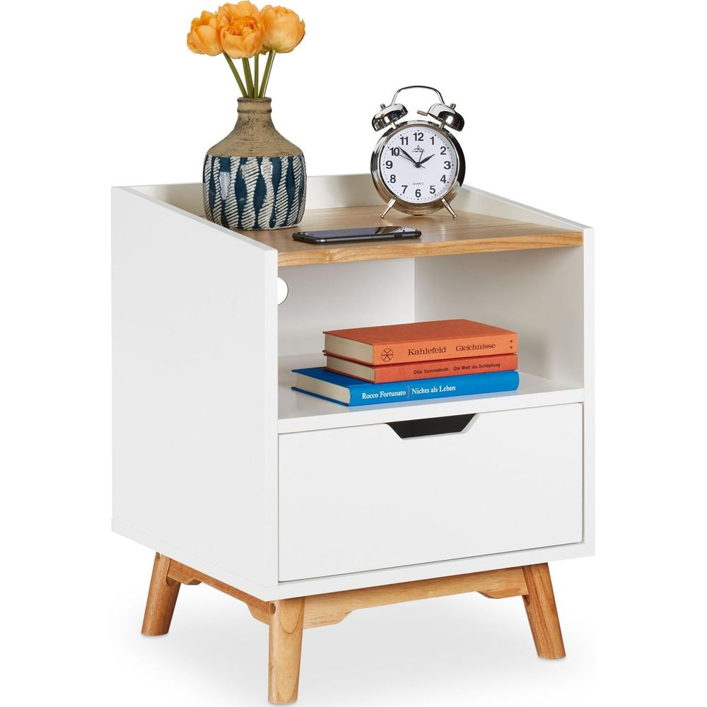 Weißer Nachttisch mit Holzbeinen, einer Schublade, Büchern, einem Wecker, Handy und Blumen.