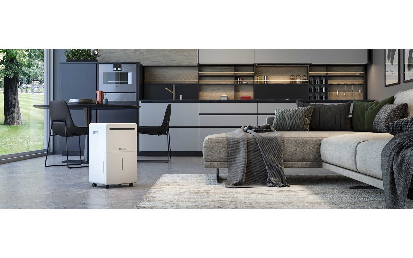 Un deumidificatore bianco con ruote si trova in un soggiorno moderno con divano grigio, tappeto e cucina sullo sfondo.
