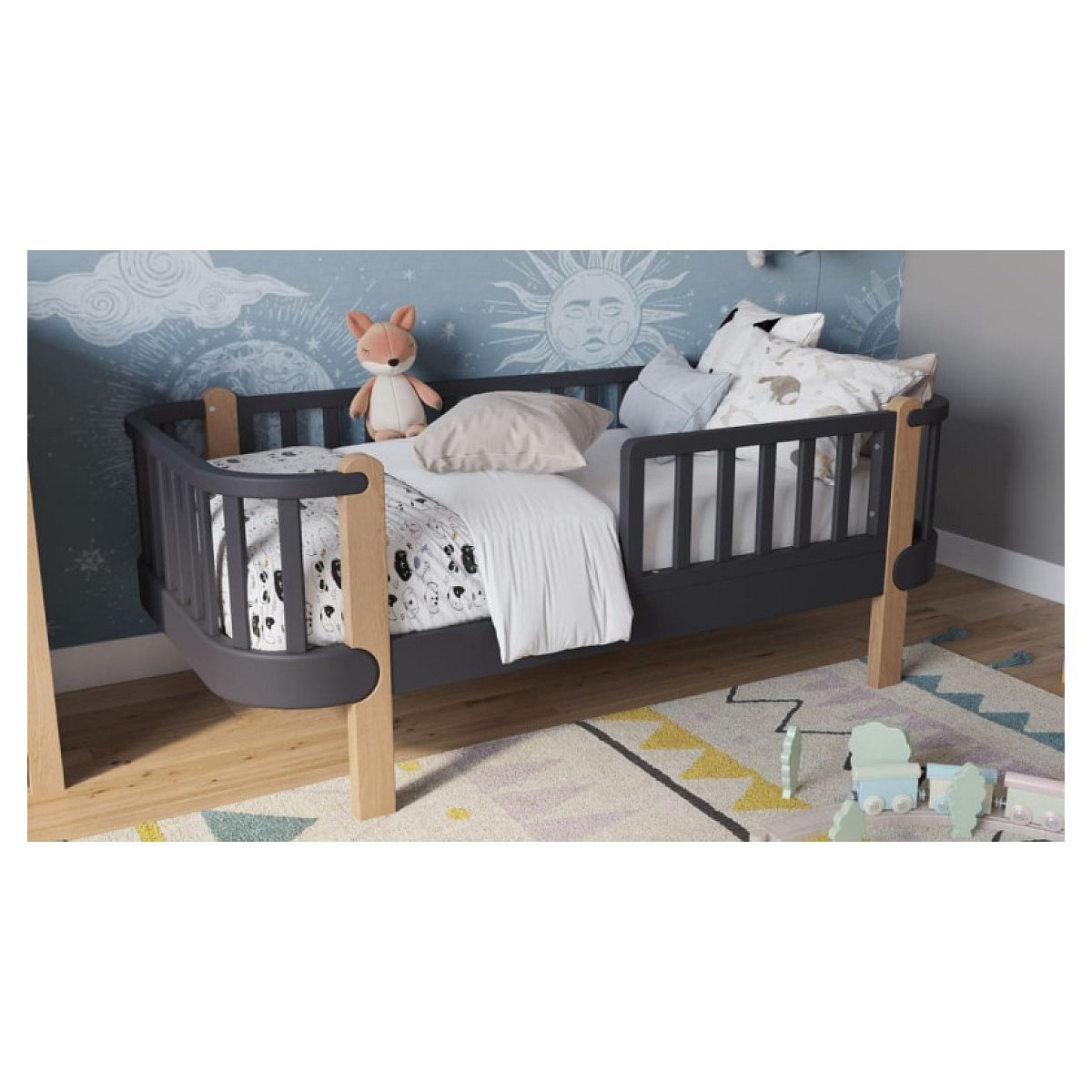 Dunkles Kinderbett mit hellen Holzbeinen, Kissen, Kuscheltier und gemustertem Teppich im Raum.