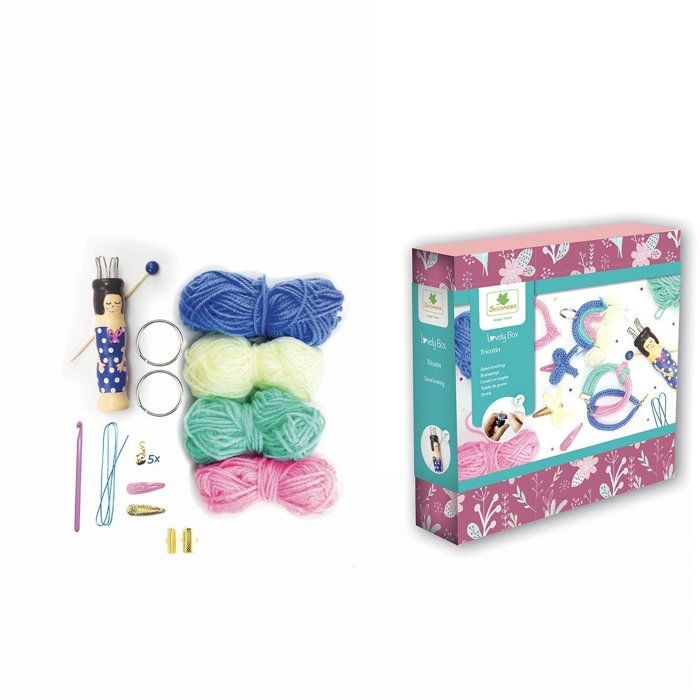 Ein Strick-Set mit buntem Garn, Holzpuppe, Häkelnadel und Zubehör neben einer rosa und blauen Box.