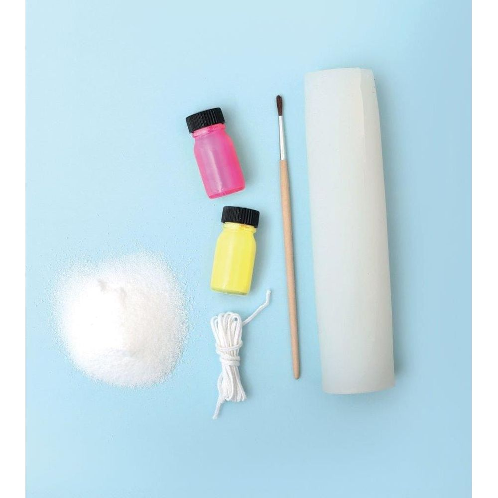 Bastelbedarf auf blau: weißes Pulver, rosa und gelbe Flaschen, Kordel, Pinsel und Kerzenform.