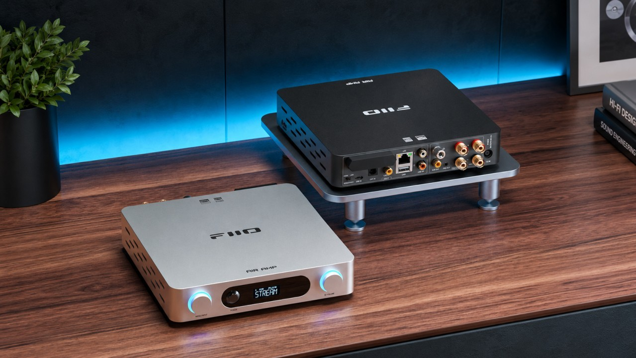 Dwa urządzenia audio FiiO Air Amp na drewnianym biurku, jedno srebrne i jedno czarne.