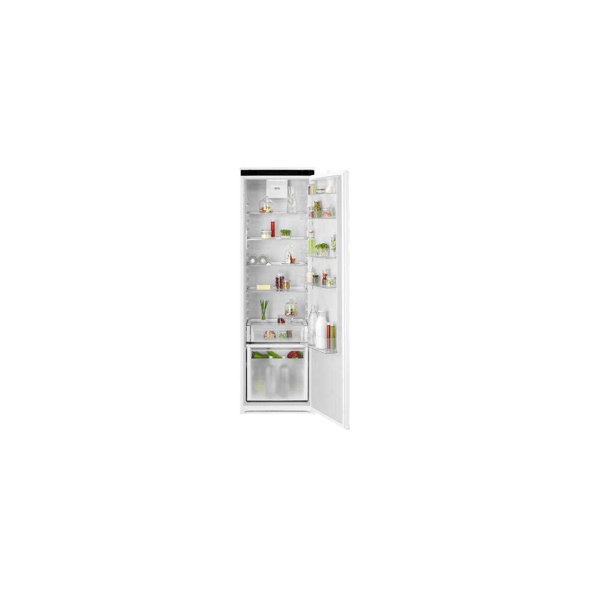 Un refrigerador empotrable blanco y abierto con estantes iluminados, lleno de varios alimentos y bebidas.