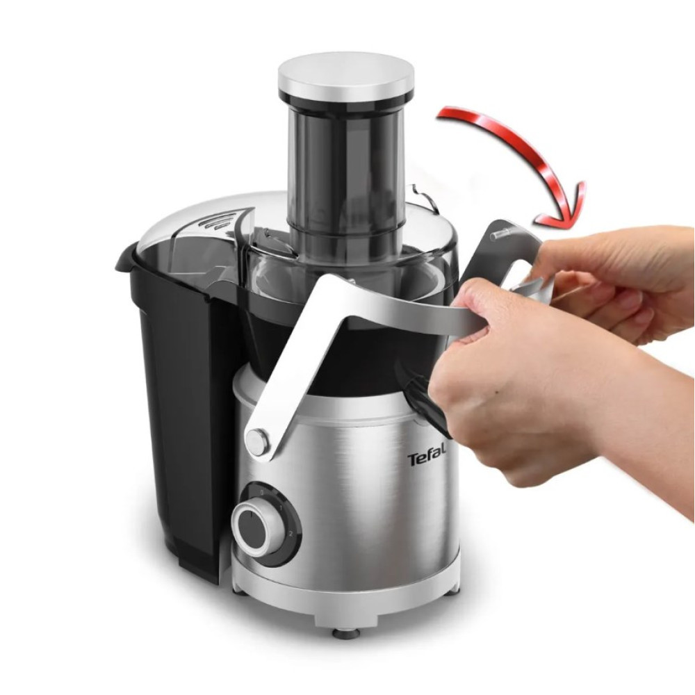 Ręce zabezpieczają ramię blokujące srebrnej sokowirówki Tefal.
