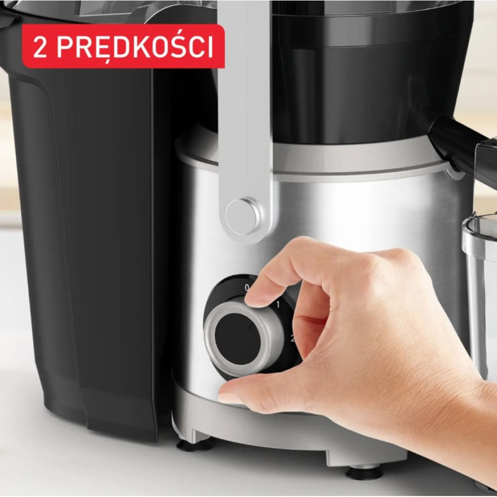Ręka obsługująca pokrętło regulacji prędkości srebrno-czarnej sokowirówki.