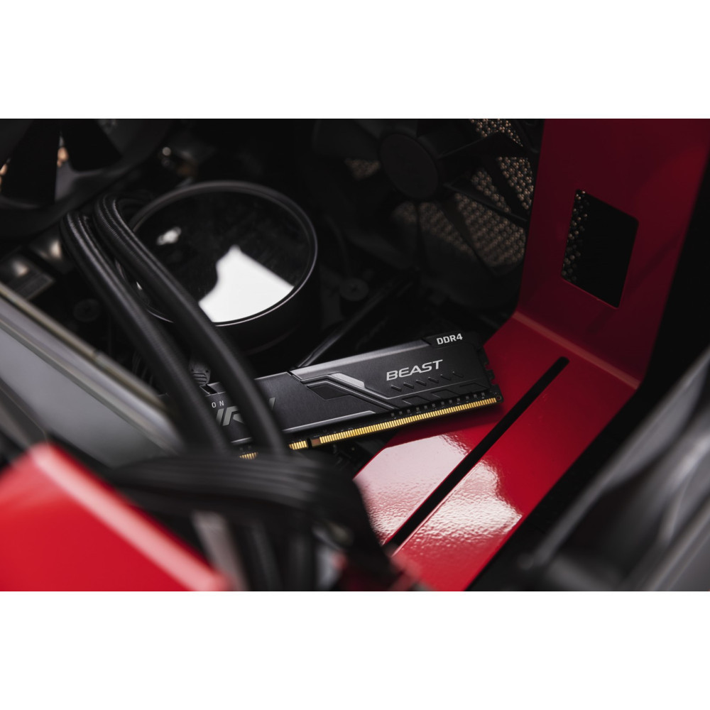 Zbliżenie wnętrza obudowy komputera z pamięcią RAM Kingston Beast DDR4, rurkami chłodzącymi i czerwonymi akcentami.