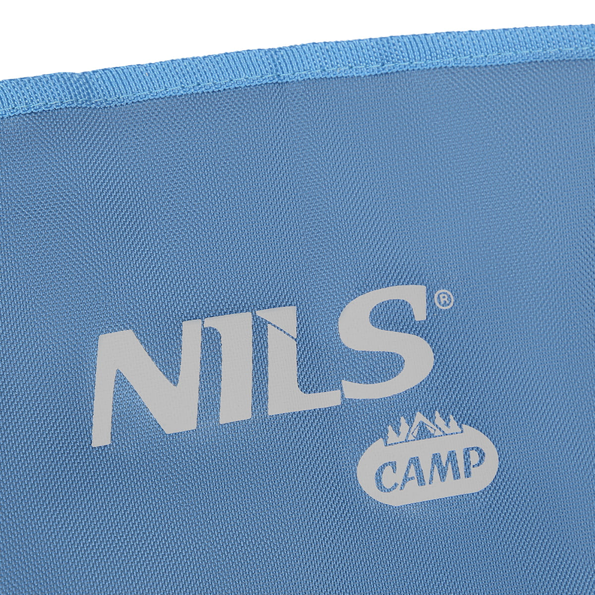 Niebieska powierzchnia materiału ze srebrnym logo NILS CAMP i niebieskim obszyciem u góry.