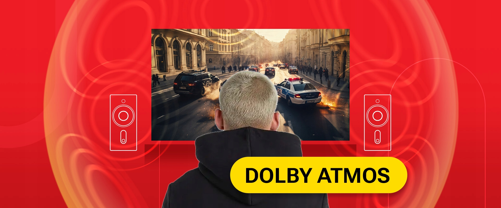 Osoba w kapturze patrzy na ekran z pościgiem samochodowym, otoczona ikonami dźwięku Dolby Atmos.
