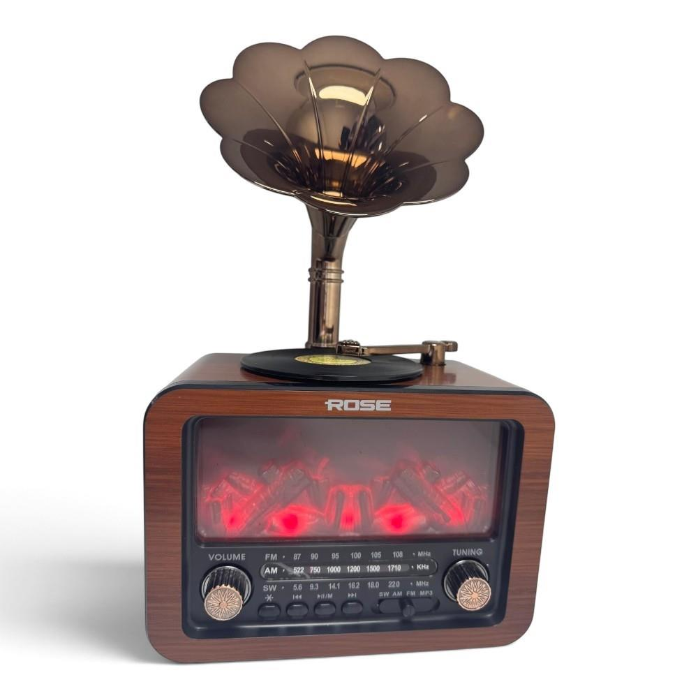 Pembe altın rengi huni hoparlörlü ve içinde parlayan kırmızı şömine efekti olan ahşap görünümlü retro radyo.