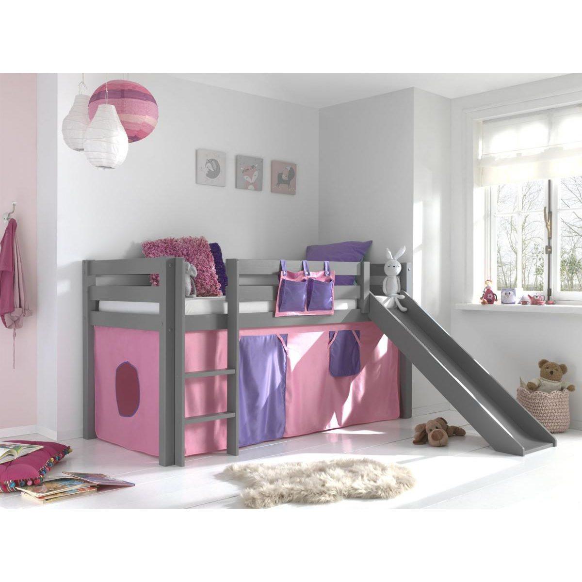 Graues Kinderhochbett mit pinker Vorhangverkleidung, Rutsche und Spielzeug im Raum.