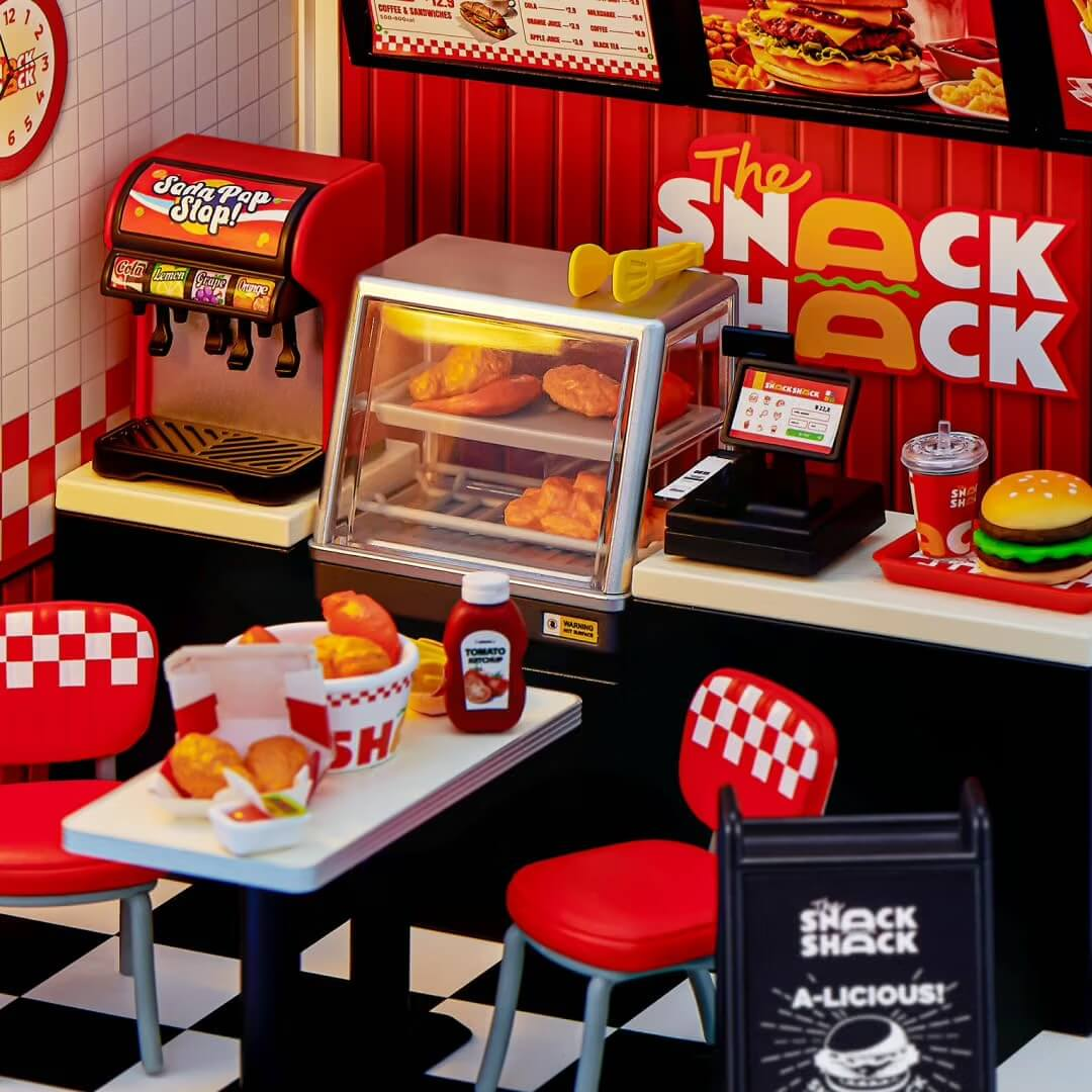 Miniatur-Imbissrestaurant namens The Snack Shack mit Tisch, Stühlen, Getränkeautomat und Lebensmitteln.