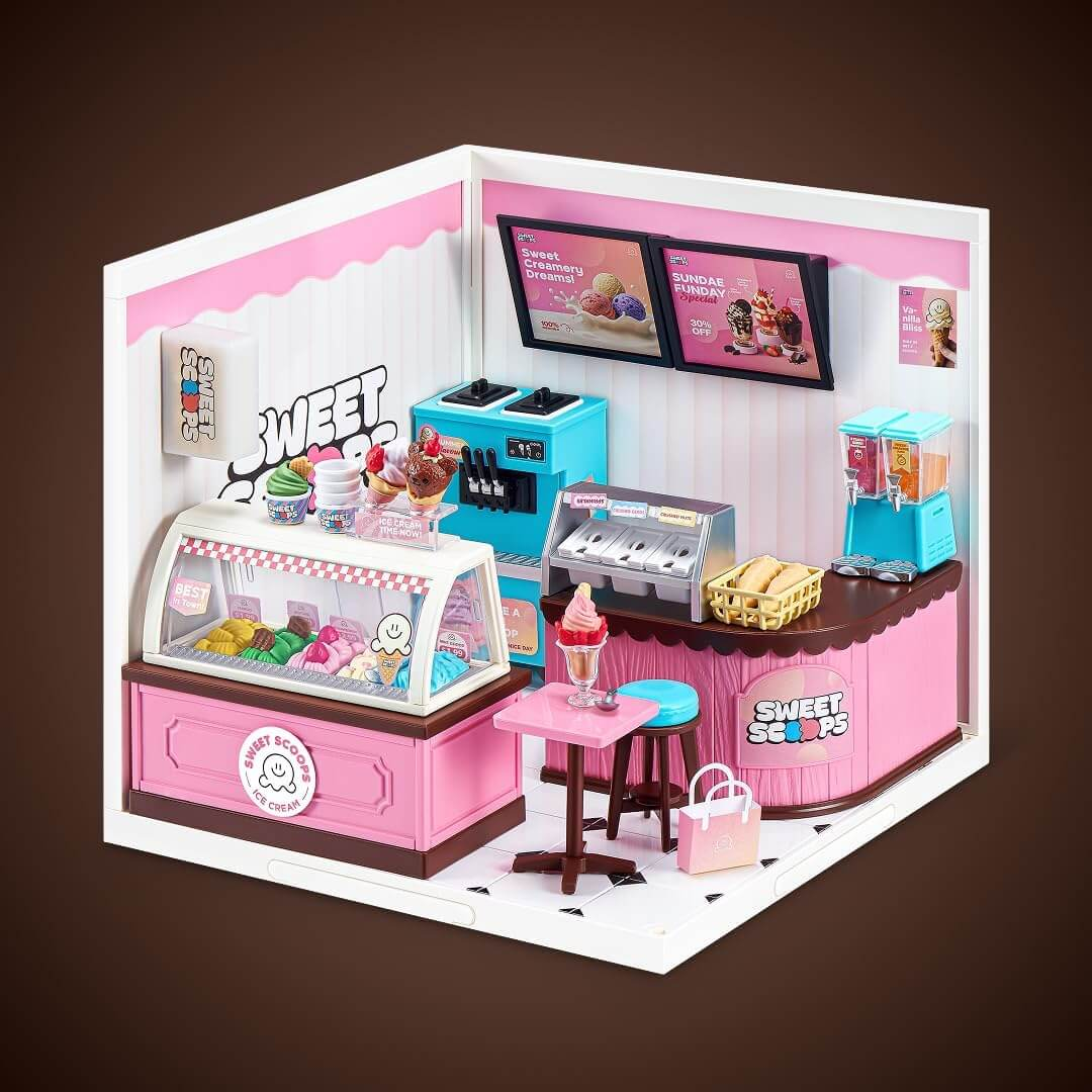 Ein detailreiches, rosa-weißes Miniatur-Eiscafe mit Theke, Eismaschine, Menükarten und Hocker vor braunem Hintergrund.