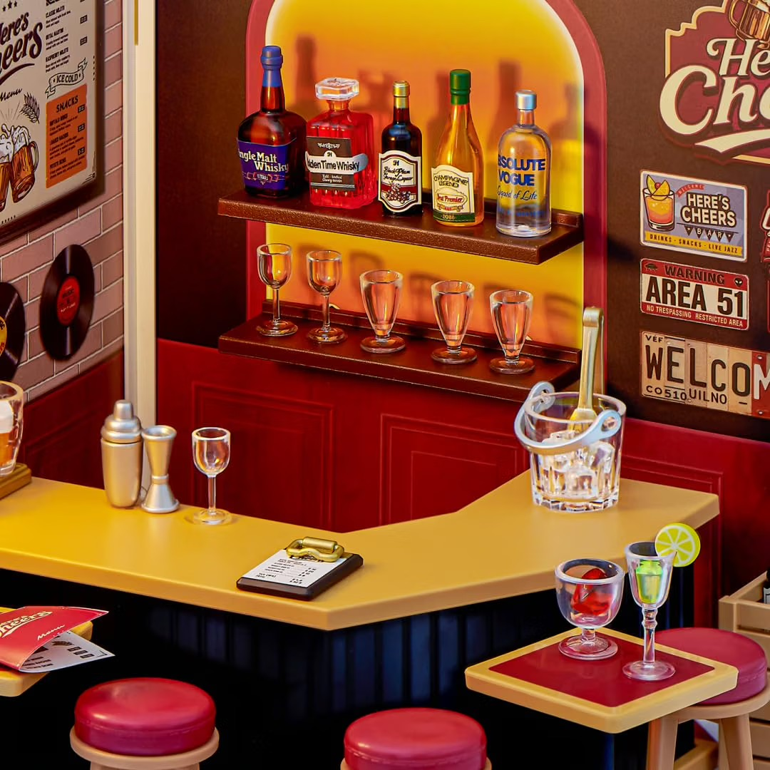 Eine detaillierte Miniatur-Bar mit Flaschen, Gläsern, einer Theke mit roten Hockern und Wandschmuck.