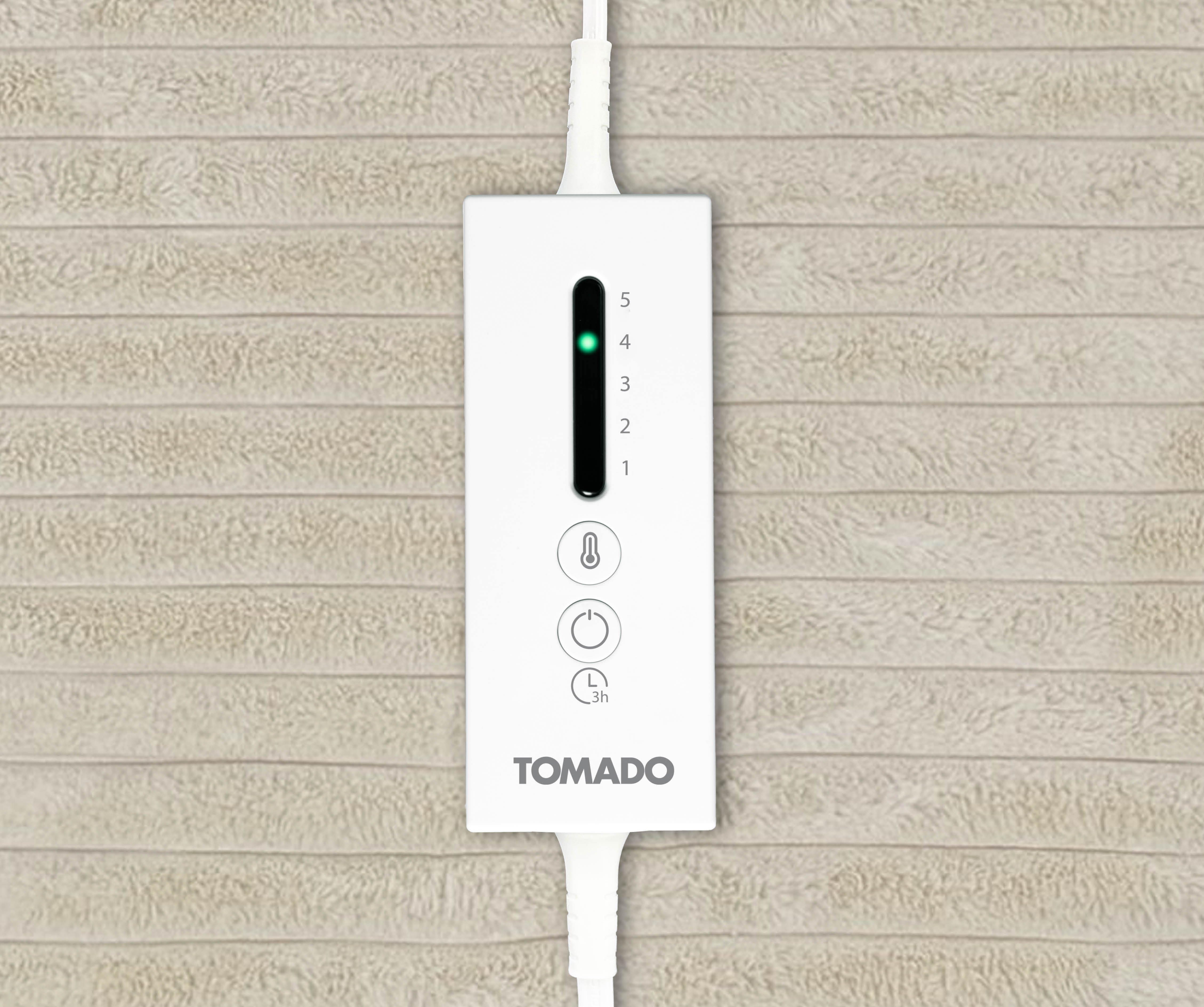 Contrôleur de couverture chauffante Tomado blanc avec indicateur LED vert niveau 4 sur tissu beige.