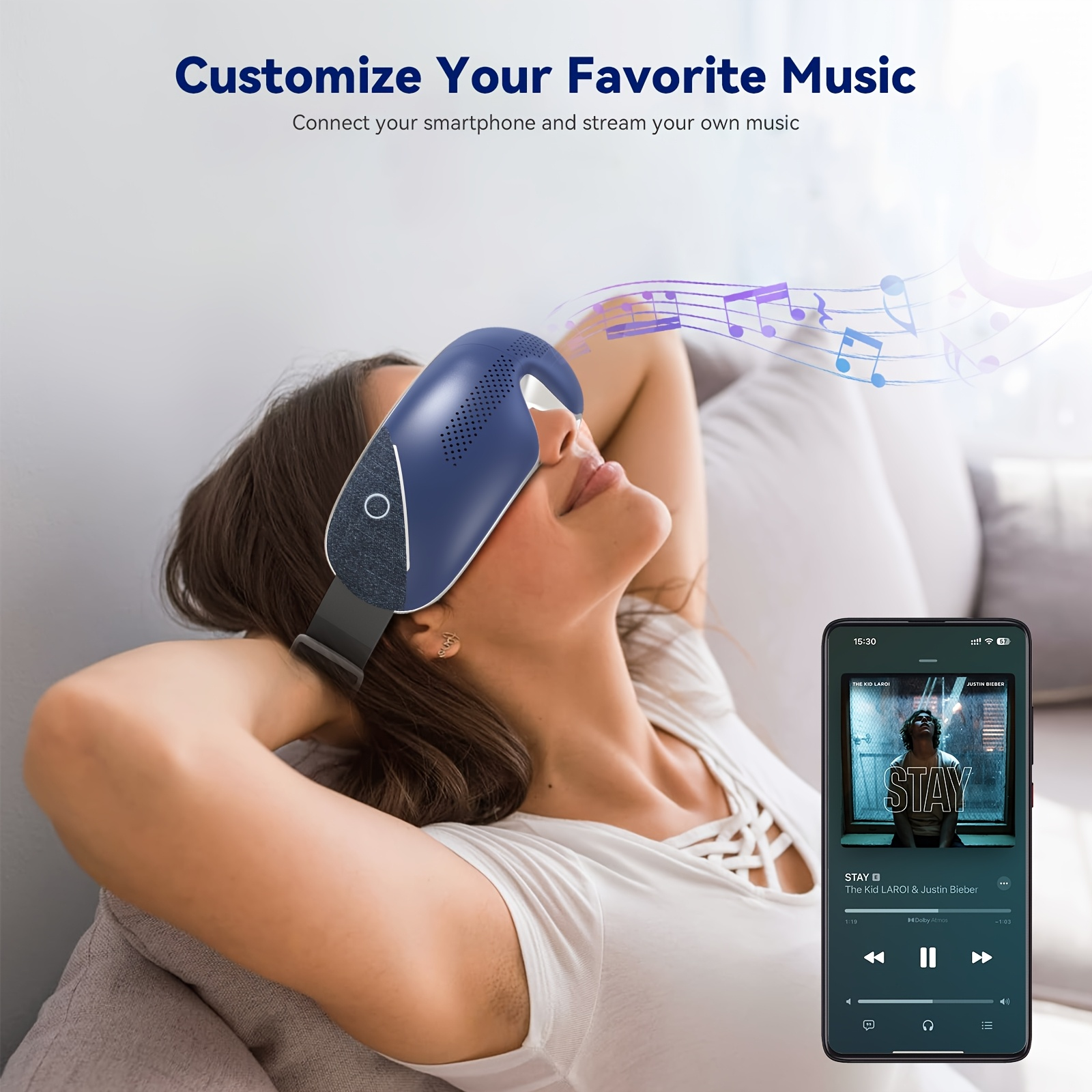 Frau mit Augenmassagegerät entspannt auf Sofa, während ein Smartphone Musik abspielt.