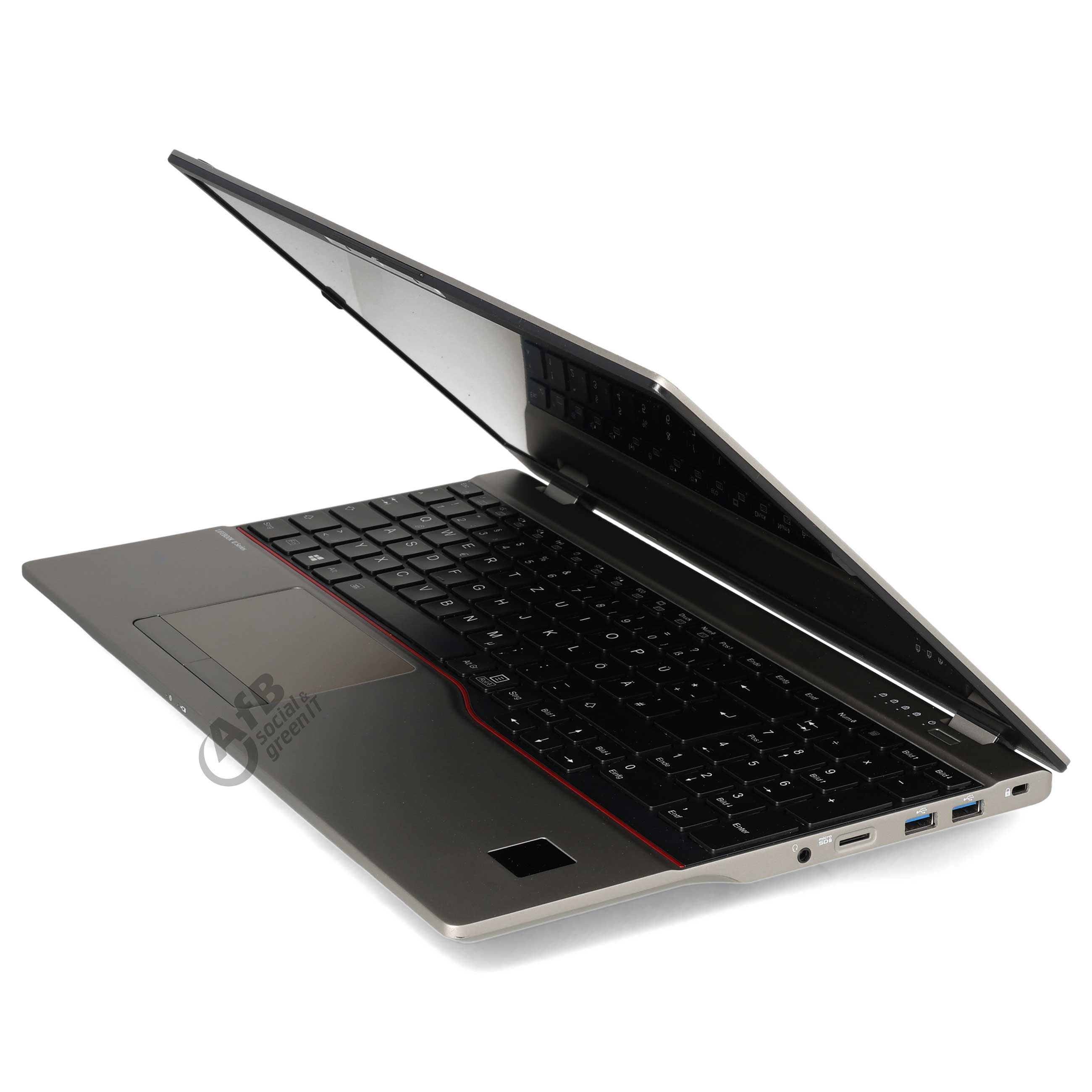 Ein geöffneter silberner Laptop von rechts, zeigt Tastatur, Touchpad und Anschlüsse vor weißem Hintergrund.