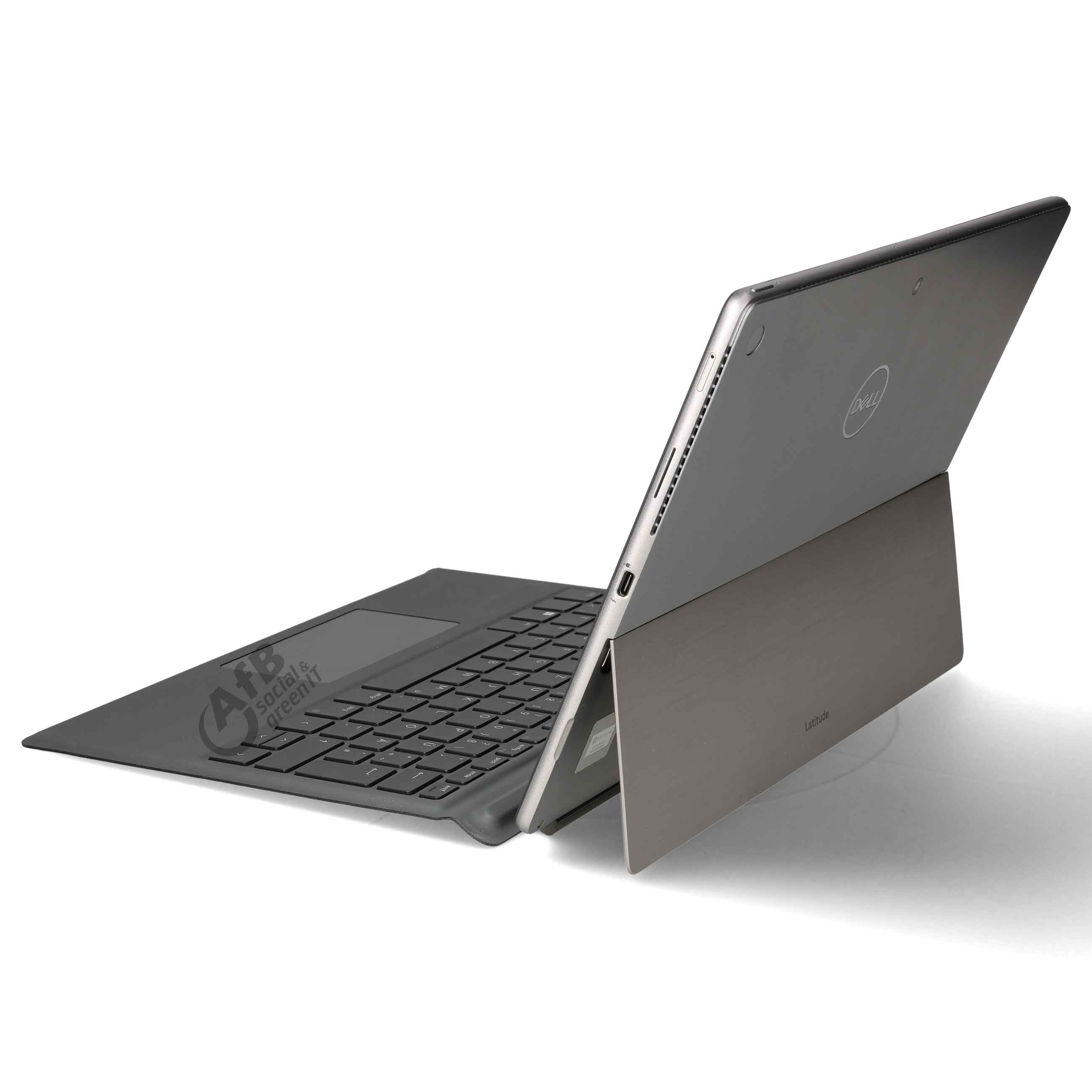 Ein silberner Laptop mit angeschlossener schwarzer Tastatur steht auf einer weißen Oberfläche.