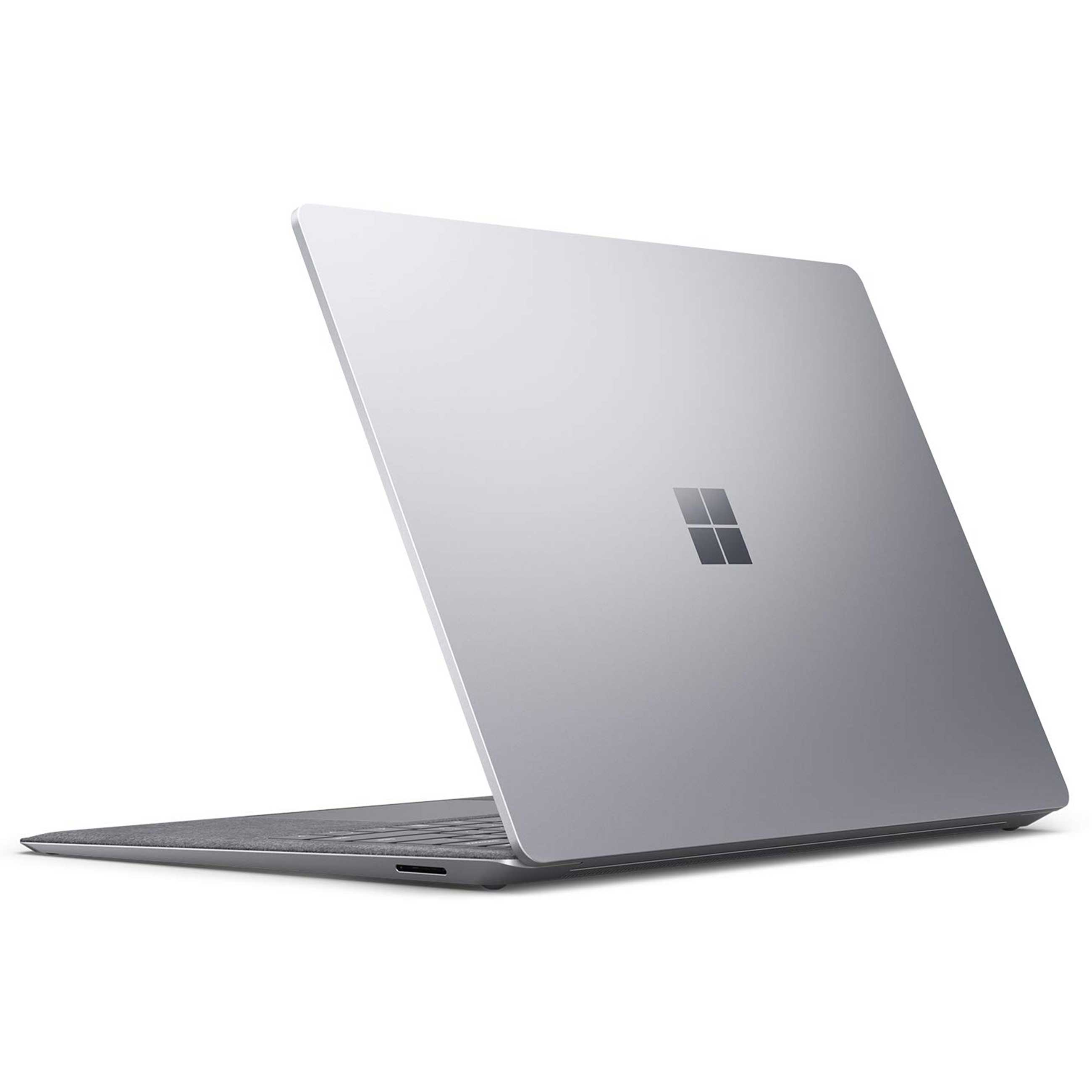 Ein silberner Laptop mit geschlossenem Bildschirm steht auf einer weißen Oberfläche, die Microsoft-Logo ist zu sehen.