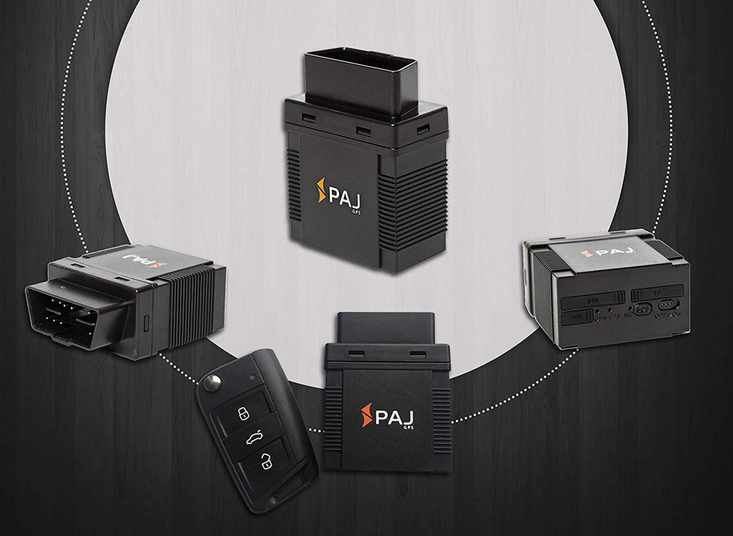 Fünf PAJ GPS OBD-Geräte aus verschiedenen Winkeln und ein Autoschlüssel auf dunklem Holzhintergrund.