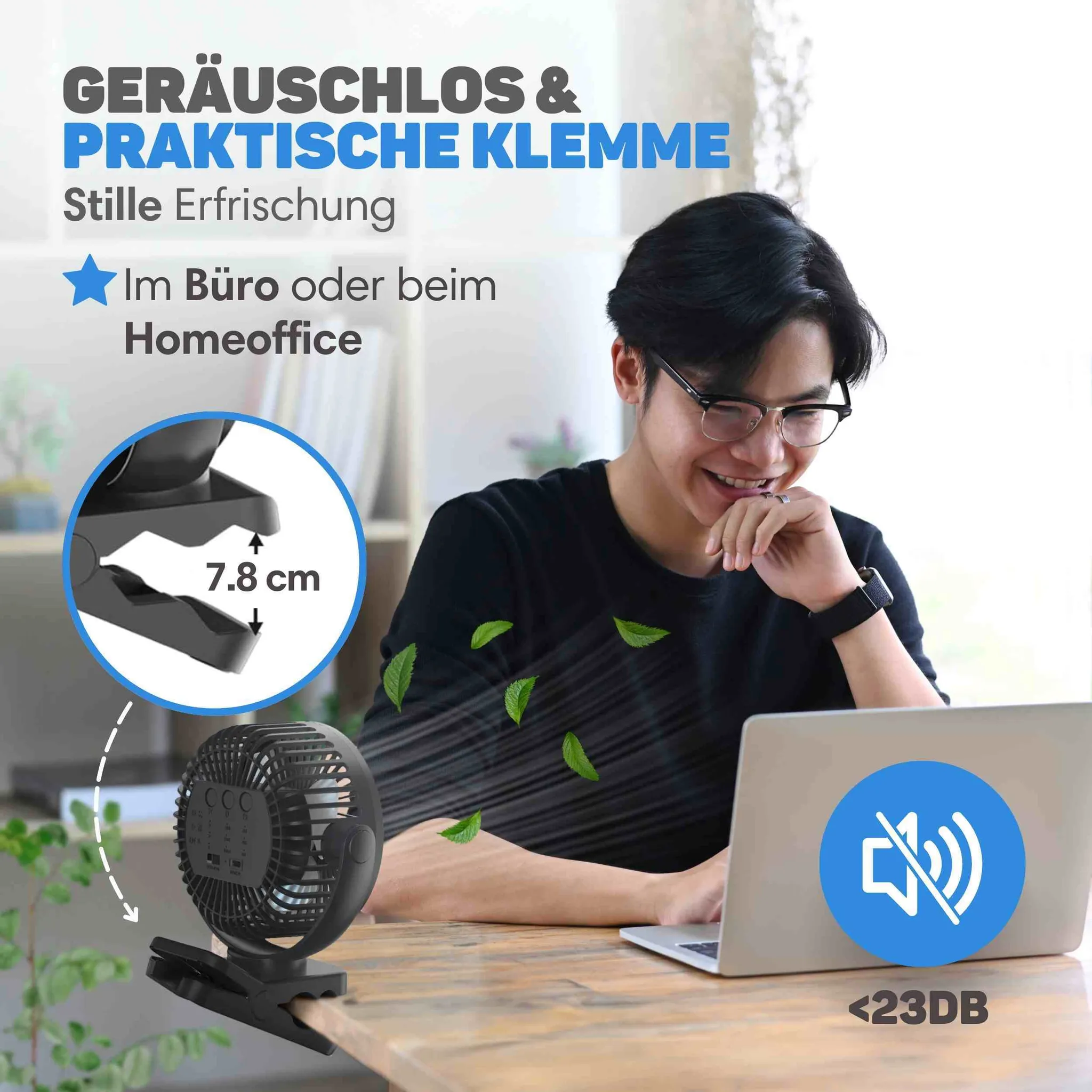 Ein Mann arbeitet an einem Laptop, während ein kleiner leiser Tischventilator auf dem Schreibtisch steht.