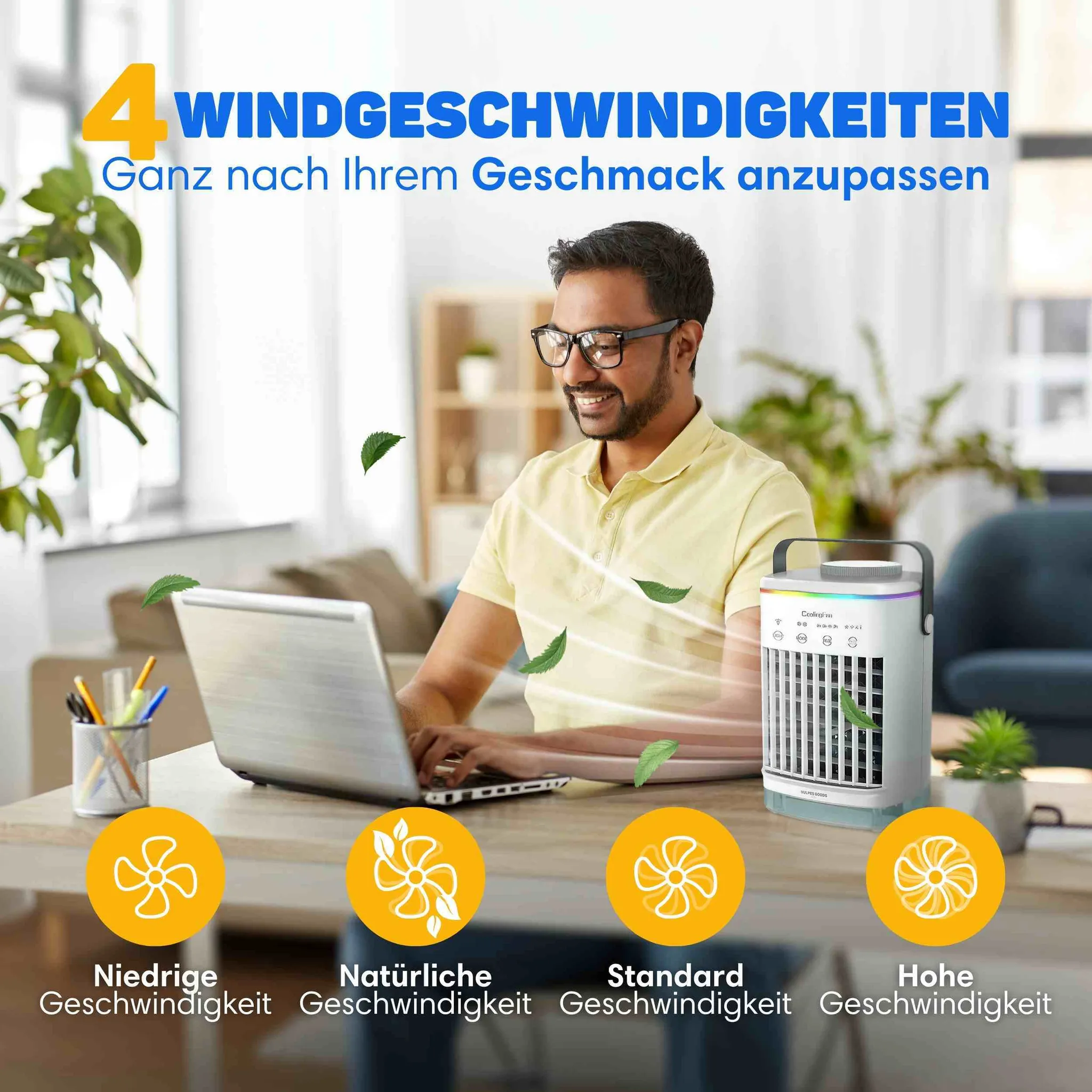 Ein Mann sitzt an einem Laptop, während ein kleiner weißer Tischventilator kühlende Luft und grüne Blätter bläst.