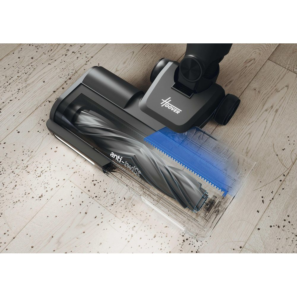 Una spazzola per aspirapolvere Hoover nera con setole anti-groviglio pulisce un pavimento in legno sporco.