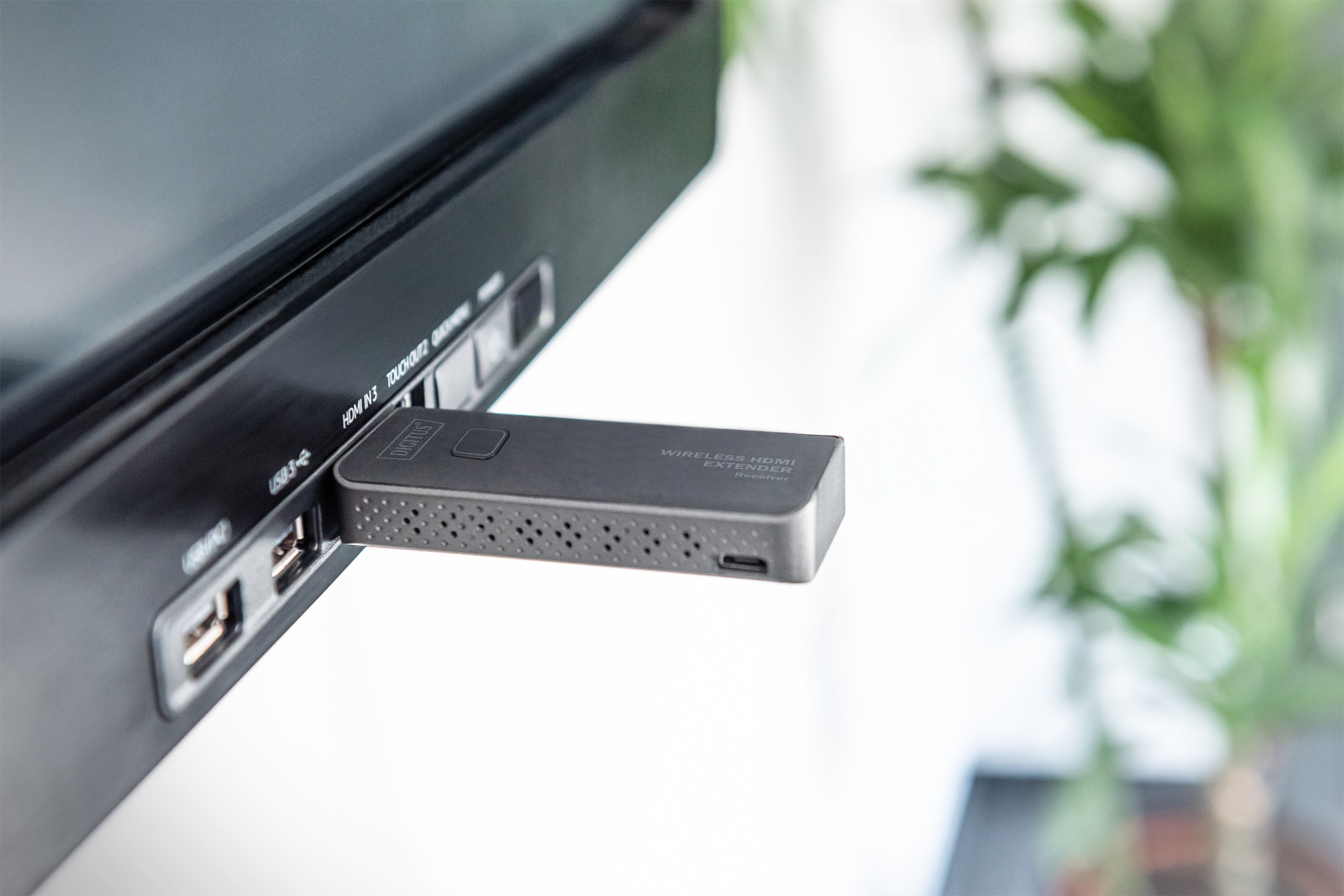 Kablosuz bir HDMI uzatıcı alıcı, siyah bir elektronik cihazın USB bağlantı noktasına takılıdır.