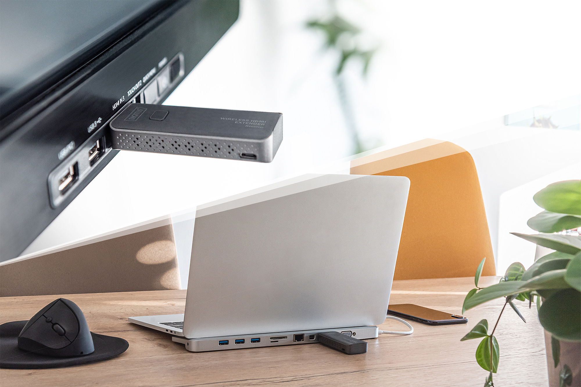 Kablosuz bir HDMI uzatıcı, bir monitörün USB bağlantı noktasına ve bir yerleştirme istasyonuna takılıdır.