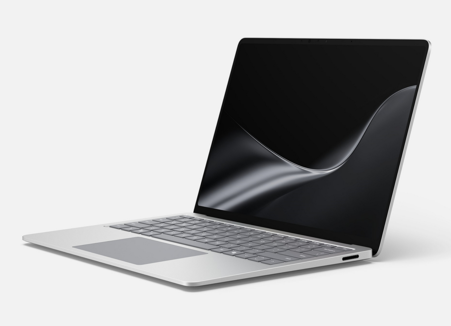 Un computer portatile argentato con uno sfondo astratto nero su una superficie bianca.