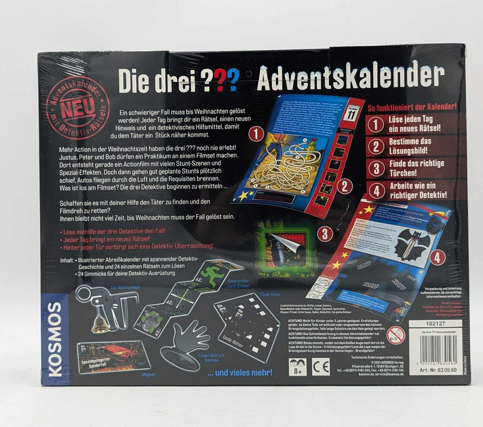 Rückseite des Die drei ??? Adventskalenders mit Texten, Rätselbildern und kleinen Gadgets.