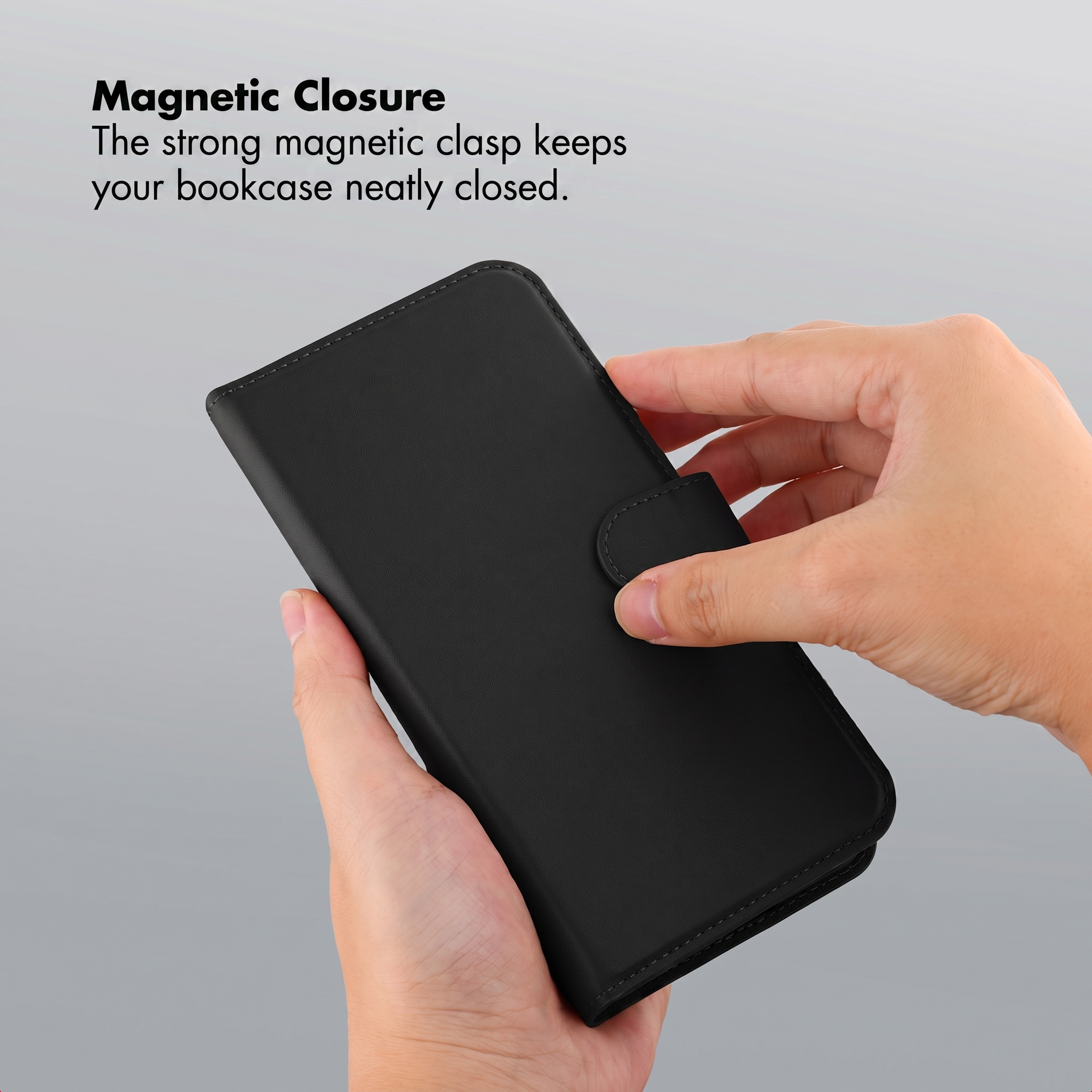 Mains tenant un étui de téléphone en cuir noir avec fermoir.