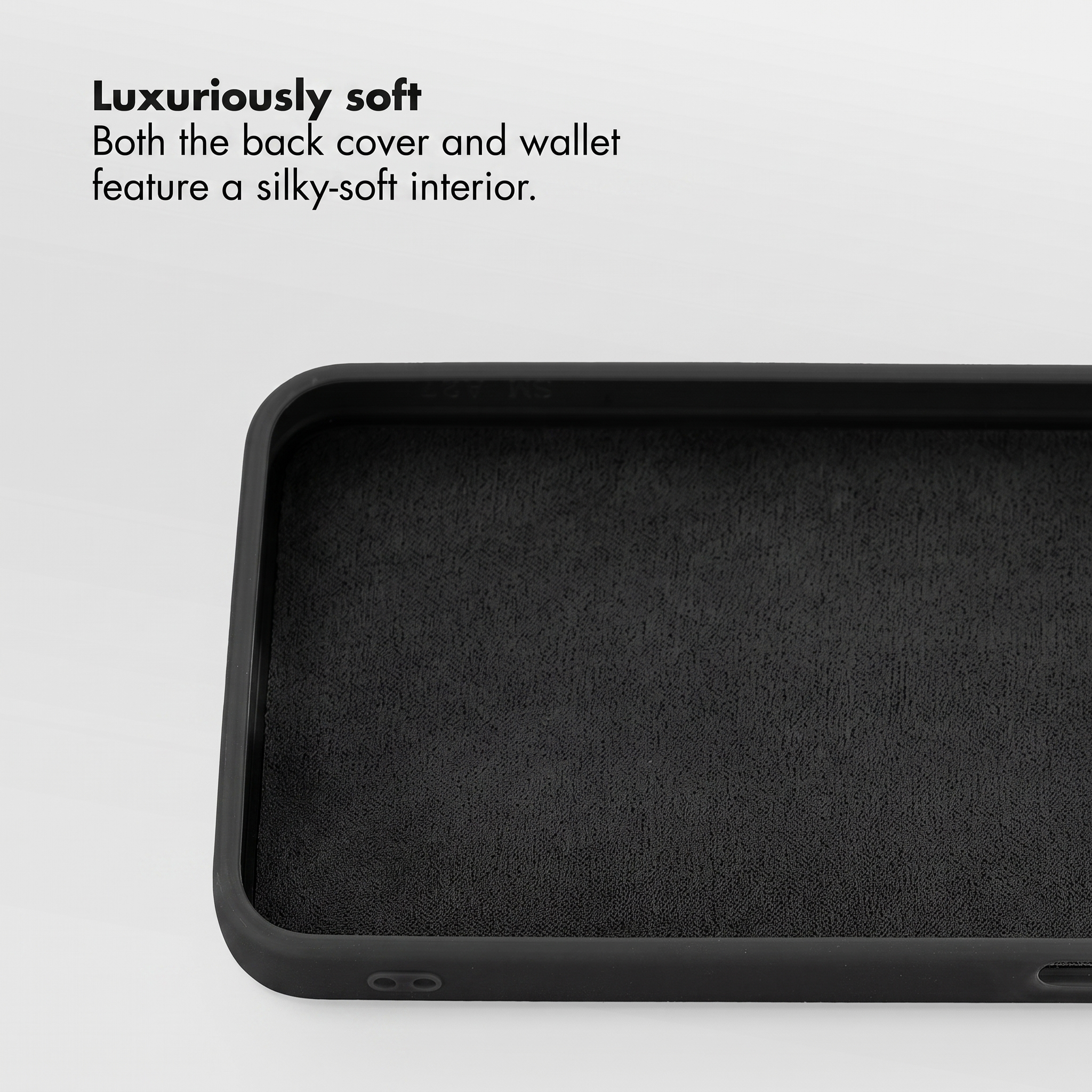 Gros plan de l'intérieur d'une coque de téléphone noire doublée d'un matériau doux, sur fond blanc.