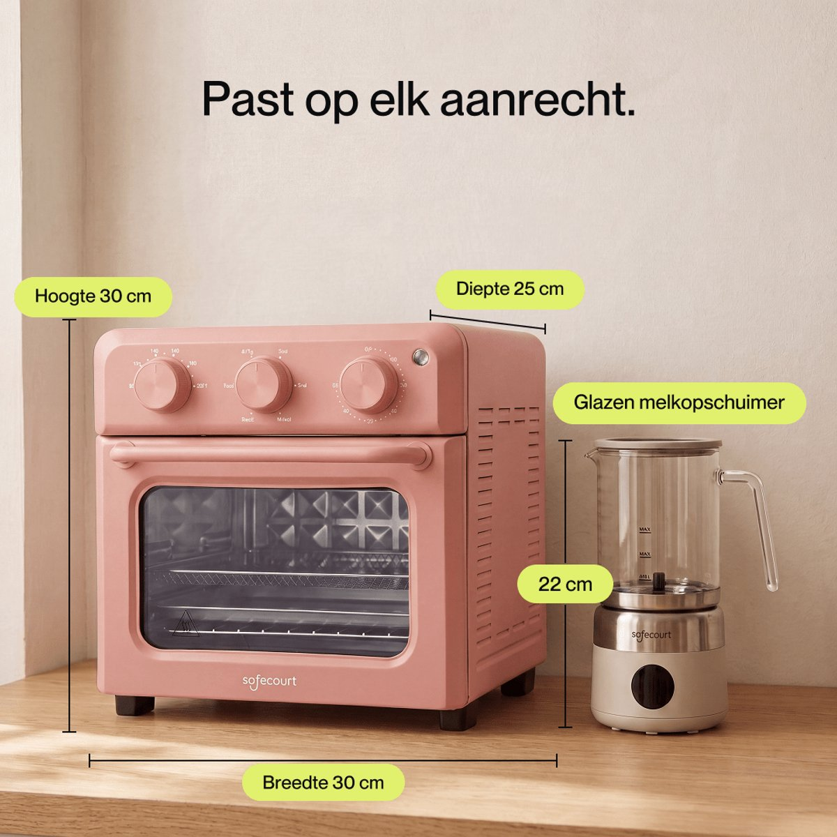 A pink compact oven and a milk frother on a countertop with dimension labels.