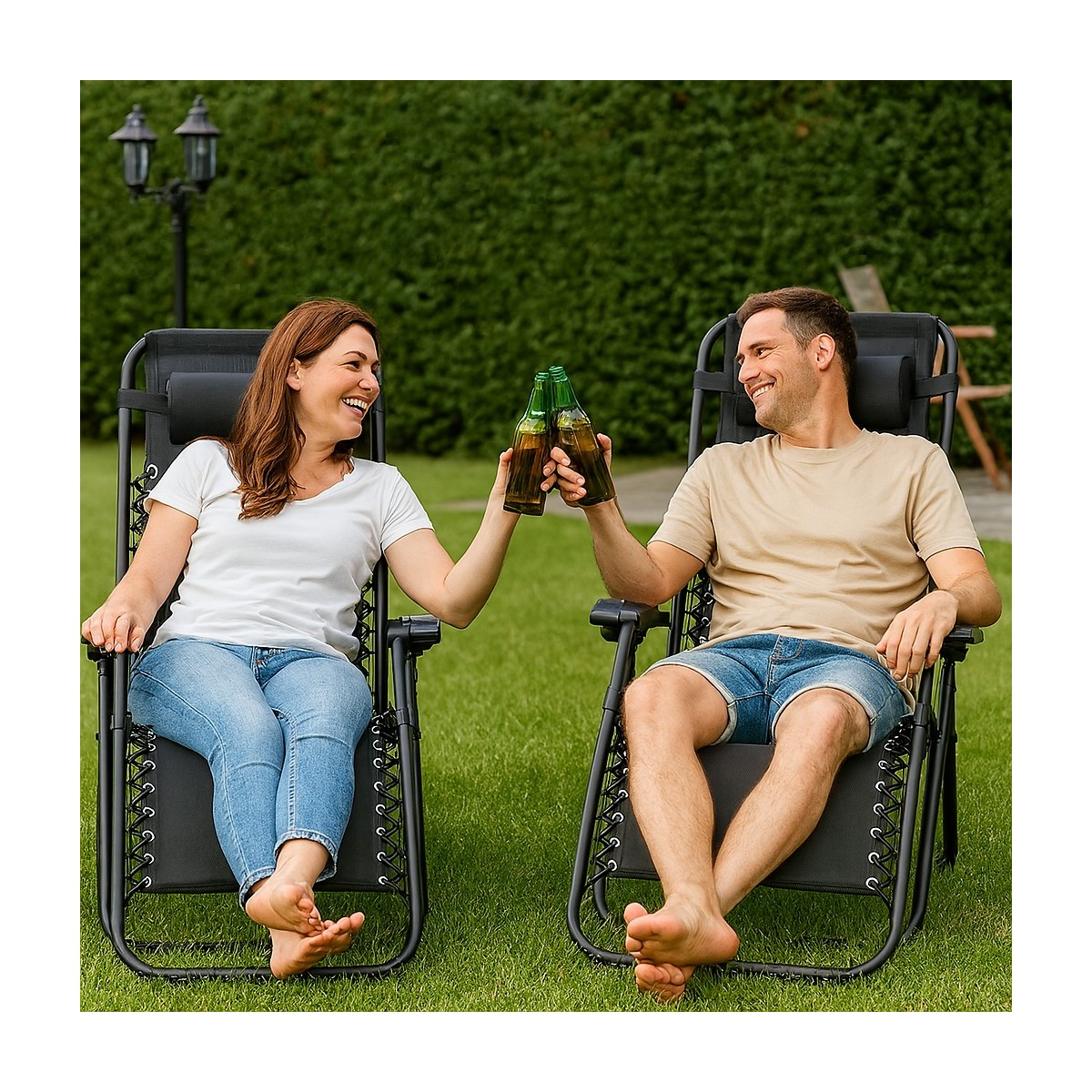 Een gelukkig koppel zit in ligstoelen op een grasveld en proost met bierflesjes.